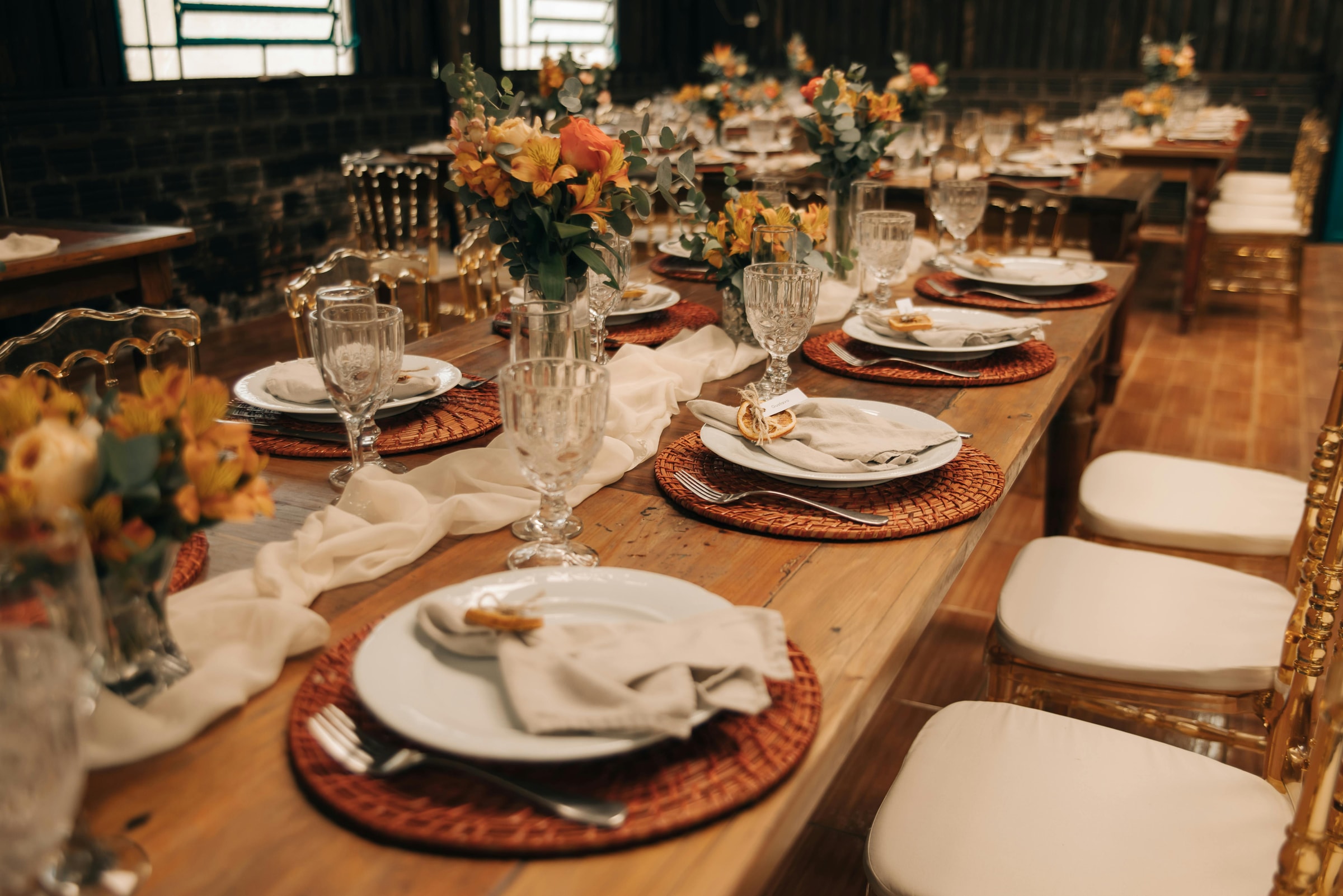 Black luxury sedan with doors open outside an illuminated event venue at night, chauffeur standing at attention