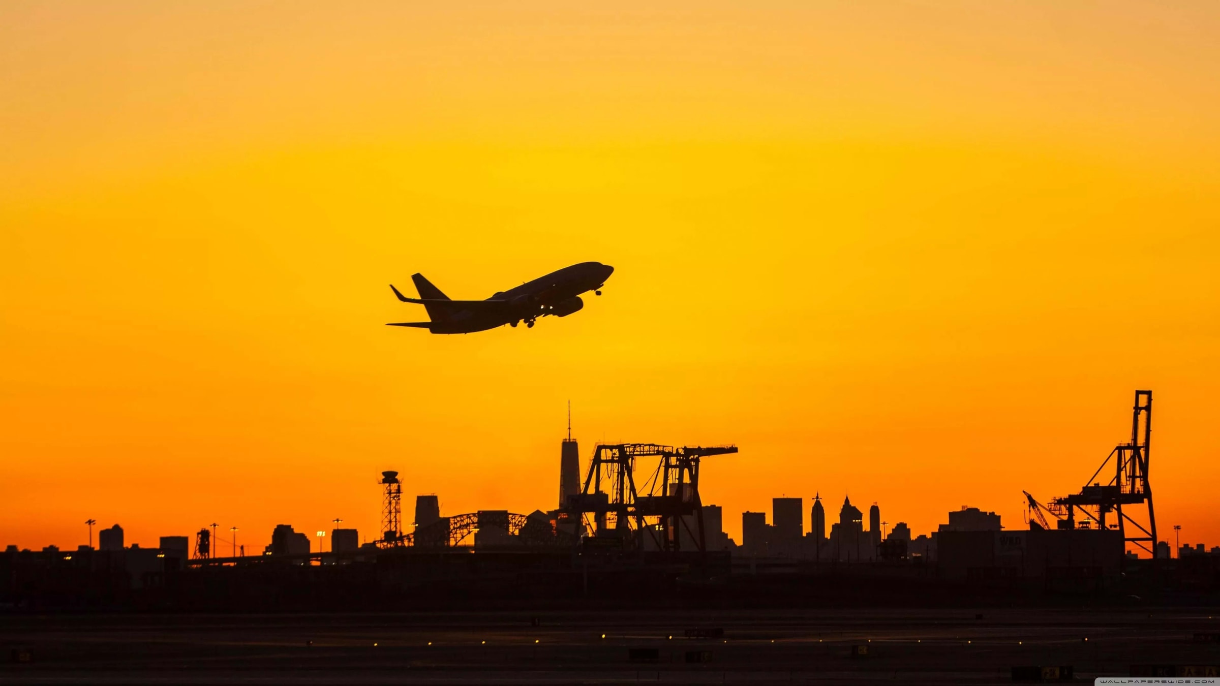 Black luxury SUV curbside at a terminal entrance at night